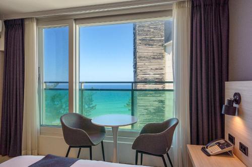 a hotel room with a table and chairs and a window at Gyeongpo Soo Hotel in Gangneung