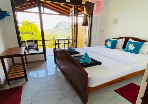 a bedroom with a large bed and a large window at Daban Homestay Ella in Ella