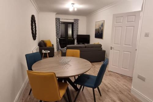 uma sala de estar com uma mesa e cadeiras e um sofá em 2 Bed Gated Apartment Westport em Westport