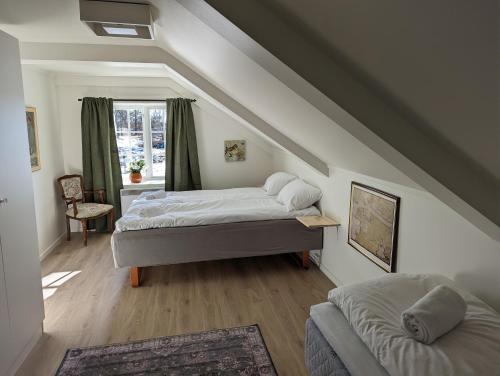 a attic bedroom with two beds and a window at Magasinet in Fredrikstad