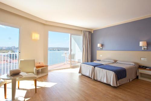 a hotel room with a bed and a large window at Seth Agamenon in Es Castell