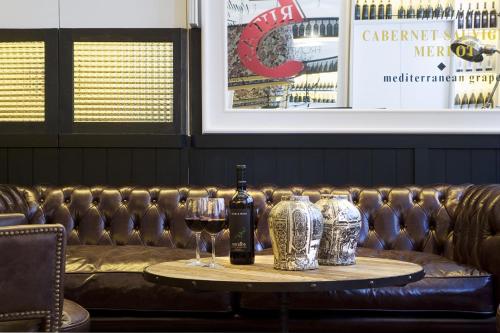 a table with two glasses of wine and a couch at Praktik Vinoteca in Barcelona