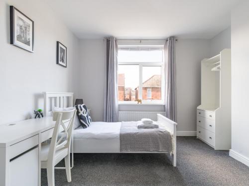a bedroom with a bed and a desk and a window at Lilys Apartment 2- 2bedroom, Northumberland in Bedlington
