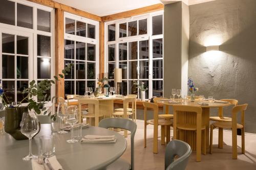 a dining room with tables and chairs and windows at St. Oberholz Woldzegarten Retreat in Leizen