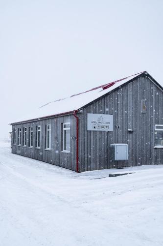 a building with a sign on it in the snow at HOTEL SNAEFELLSNES formally Hotel Rjukandi in Vegamót
