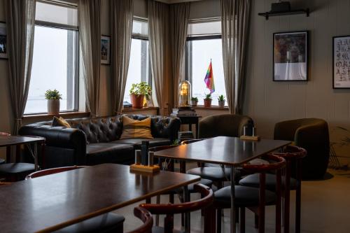 a waiting room with tables and couches and windows at HOTEL SNAEFELLSNES formally Hotel Rjukandi in Vegamót
