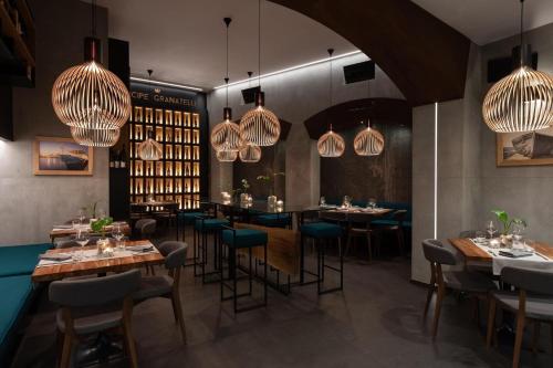 a restaurant with tables and chairs and chandeliers at La Dimora del Principe Luxury House in Mazara del Vallo