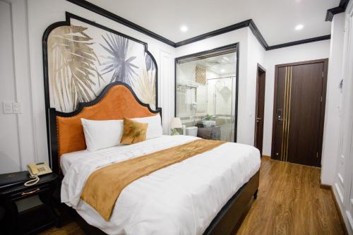 een slaapkamer met een groot bed met een groot hoofdeinde bij HƯỚNG DƯƠNG HOTEL THANH HOÁ in Thanh Hóa