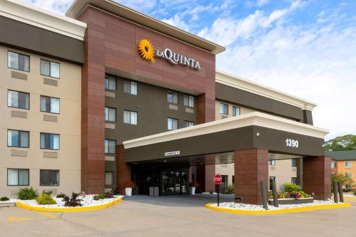 a hotel with a sun sign on the front of it at La Quinta by Wyndham Des Moines West Clive in Clive