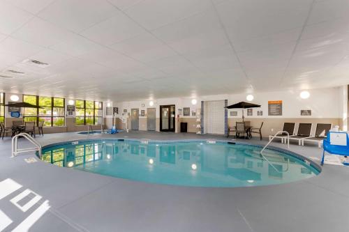 una gran piscina en una gran habitación con mesas y sillas en La Quinta by Wyndham Des Moines West Clive, en Clive