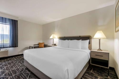 a hotel room with a large white bed and a window at La Quinta by Wyndham Des Moines West Clive in Clive