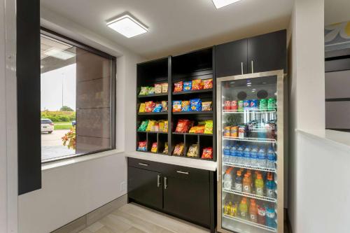 a kitchen with a refrigerator filled with lots of drinks at La Quinta by Wyndham Des Moines West Clive in Clive