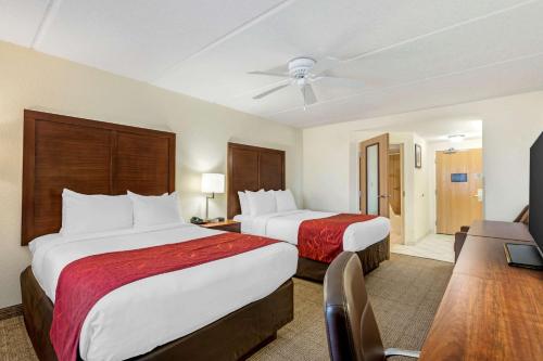 a hotel room with two beds and a flat screen tv at Comfort Inn Kissimmee-Lake Buena Vista South in Kissimmee