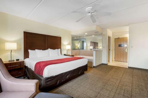 duży pokój hotelowy z łóżkiem i krzesłem w obiekcie Comfort Inn Kissimmee-Lake Buena Vista South w mieście Kissimmee
