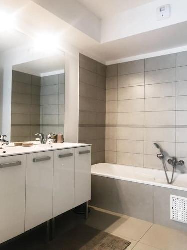 une salle de bain avec une baignoire et un lavabo et une baignoire dans l'établissement SUPERBE APPARTEMENT SUR PLAGE VUE PARADISIAQUE PIEDS DANS L'EAU, à Propriano