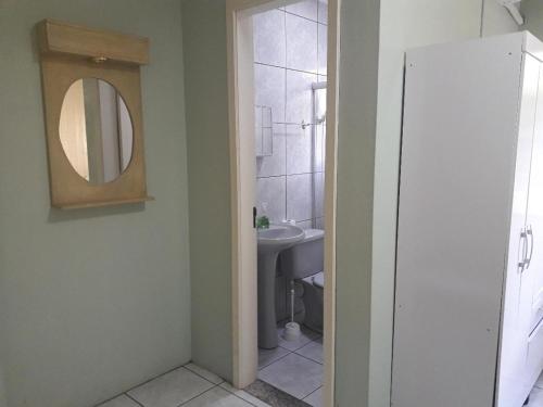 een badkamer met een wastafel en een spiegel bij APARTAMENTOS BELLO VALE in Gramado