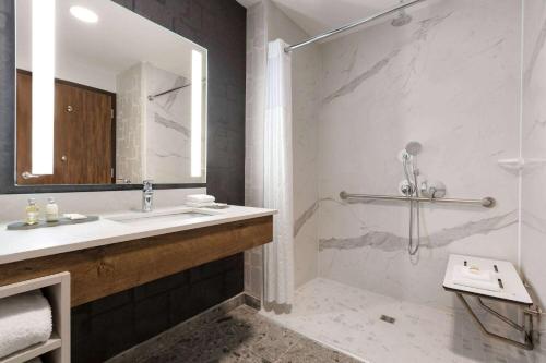 a bathroom with a shower and a sink and a mirror at La Quinta Inn & Suites by Wyndham Santa Rosa Sonoma in Santa Rosa