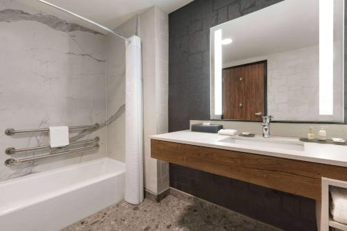 La salle de bains est pourvue d'un lavabo, d'une baignoire et d'un miroir. dans l'établissement La Quinta Inn & Suites by Wyndham Santa Rosa Sonoma, à Santa Rosa