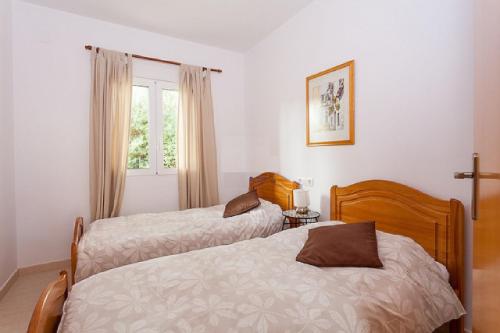 1 dormitorio con 2 camas y ventana en Pinella a lovely 2 Bed Apt. La Sella Golf Urb., en Denia