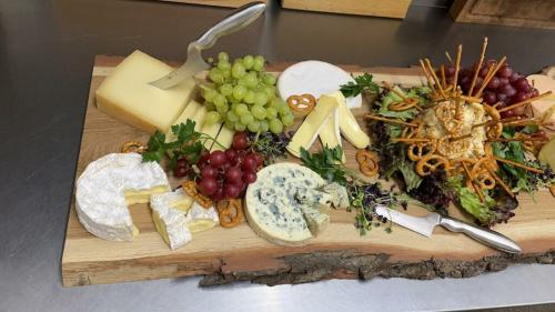 a cutting board filled with different types of cheese and grapes at Gasthof Hirsch in Schollbrunn