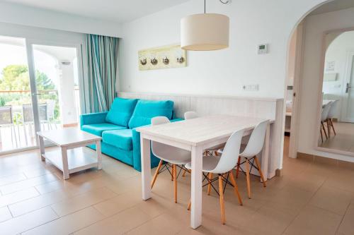 a living room with a table and a blue couch at Seth Mestral & Llebeig in Santo Tomás