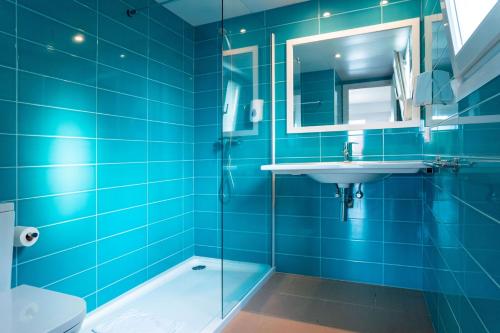 Baño azul con lavabo y espejo en Seth Mestral & Llebeig, en Santo Tomás