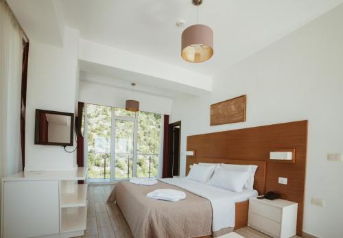 1 dormitorio con cama y ventana en Prince Adriatic Resort, en Shëngjin