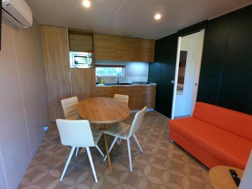 a kitchen and dining room with a table and a couch at Camping Villaggio Il Collaccio in Preci