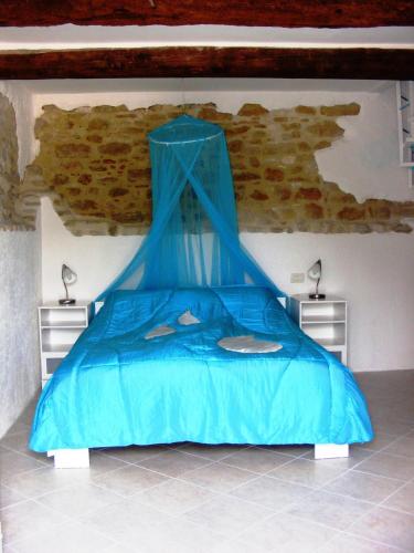 a bed with a blue canopy in a room at Agriturismo Carincone in Pergola