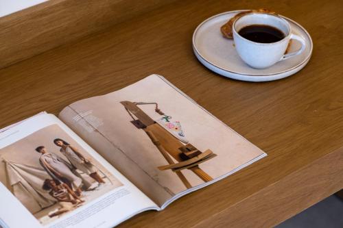 a book and a cup of coffee on a table at IRIS SUITES NIKITI in Nikiti
