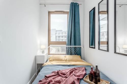 a small bedroom with a bed and a window at Chill Apartments Wilanów in Warsaw