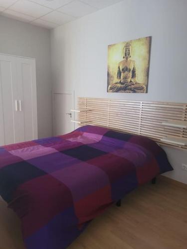 a bedroom with a bed with a painting on the wall at Apartamento kuko con wifi al lado metro in Bilbao