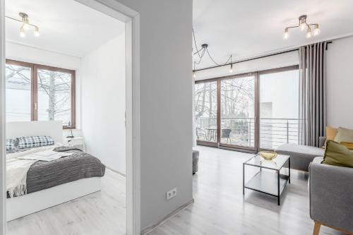 a bedroom with a king sized bed and a living room at Chill Apartments Bociania in Warsaw