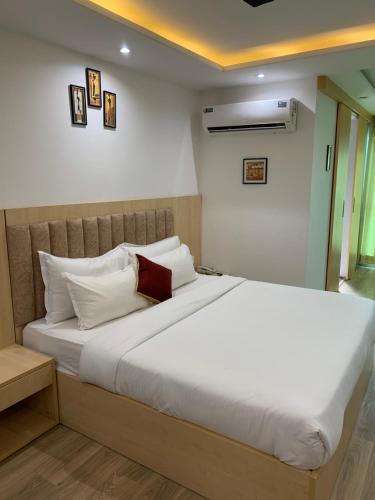 a bedroom with a large bed with white pillows at Balconies & Venue ( The Grand Anukampa) in Jaipur