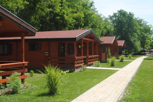 a row of wooden cabins in a park at Villa Hedi Vendégház in Dunakiliti