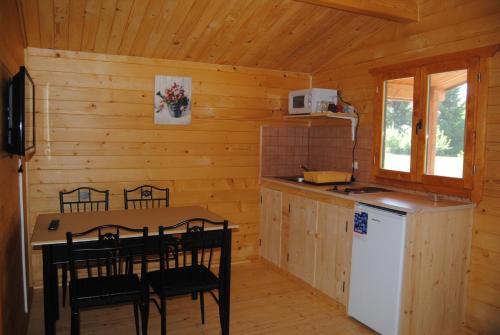una cocina con mesa y sillas en una cabaña en Villa Hedi Apartman, en Dunakiliti