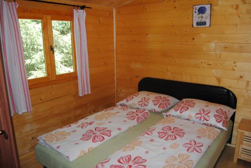 a bedroom with a bed in a log cabin at Villa Hedi Vendégház in Dunakiliti