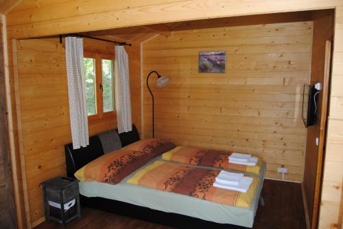 1 dormitorio con 2 camas en una cabaña de madera en Villa Hedi Apartman, en Dunakiliti
