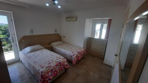 sypialnia z 2 łóżkami i oknem w obiekcie Wonderful Villa In Oludeniz 2 w mieście Kayakoy