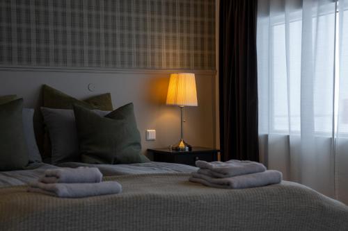 a bedroom with a bed with towels on it at HOTEL SNAEFELLSNES formally Hotel Rjukandi in Vegamót