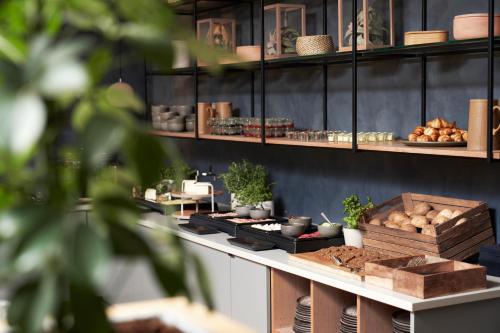 a bakery with a counter with food on it at Hotel Oasia Aarhus City in Aarhus