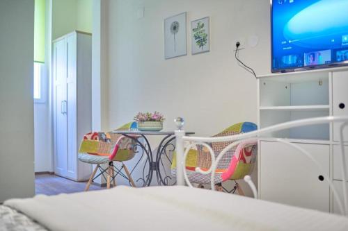 a room with a table and chairs and a tv at Old City Romantic Studios 2 in Pula