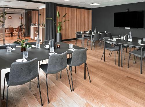a conference room with tables and chairs and a flat screen tv at Hotel Oasia Aarhus City in Aarhus