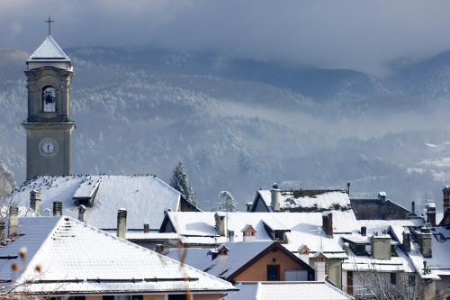 a town with a clock tower and snow covered roofs at Hotel Pian del Sole in Sassello