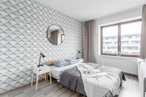 a bedroom with a bed and a mirror on the wall at Chill Apartments Bociania in Warsaw
