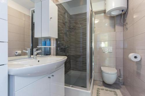 a bathroom with a sink and a shower and a toilet at Apartments Hodanić in Krk