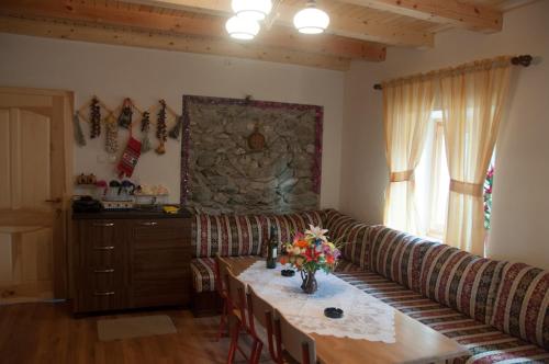 a living room with a couch and a table with flowers at Aste Guesthouse in Tropojë