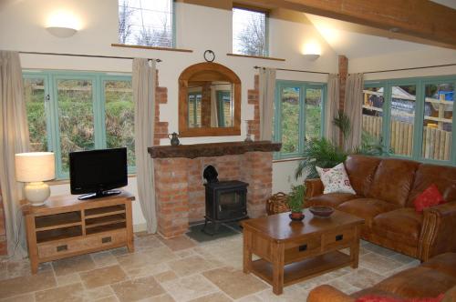 a living room with a couch and a fireplace at Honeysuckle Farm cottages in Glastonbury