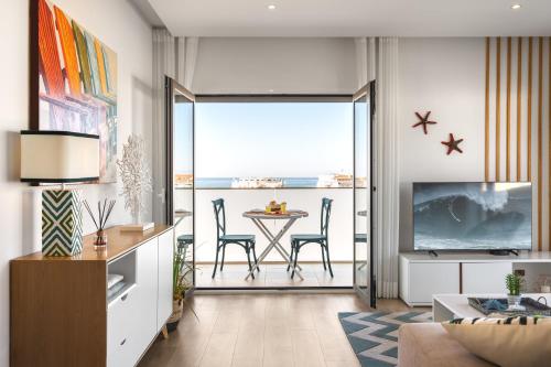 a living room with a table and a view of the ocean at Ocean Lookout with private parking in the heart of Nazaré in Nazaré
