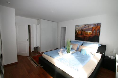 a bedroom with a large bed with a painting on the wall at Ferienwohnungen Wyk/Föhr in Wyk auf Föhr